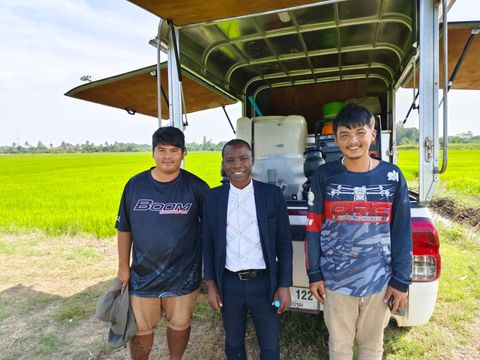 Drone operators with their service vehicle beside a rice field