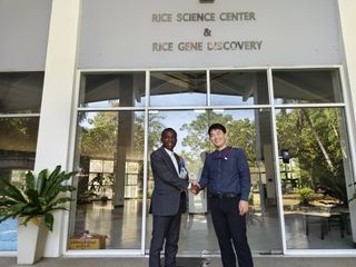 Handshake in front of the Rice Science Center and Rice Gene Discovery building